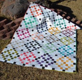 A colorful quilt laying in the grass