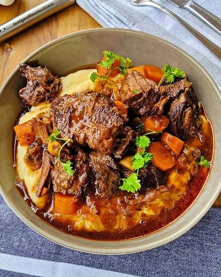 Ein tiefer Teller mit Boeuf Bourguignon und Kartoffelpüree.