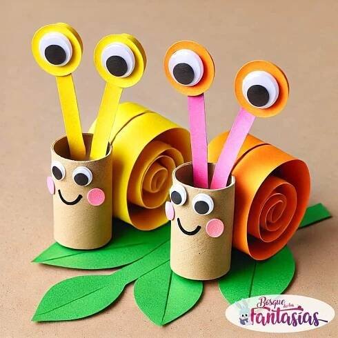 some paper cups with googly eyes are sitting on top of green leaves and flowers