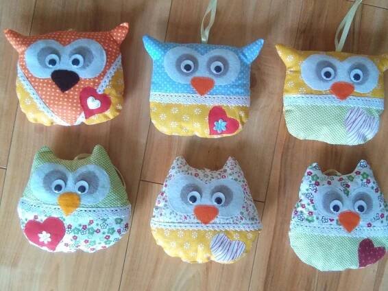 four stuffed owls are sitting on the floor