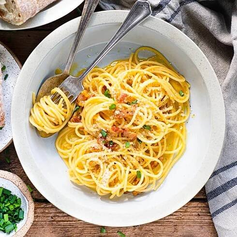 Square overhead image of a basic spaghetti carbonara recipe in a white bowl.