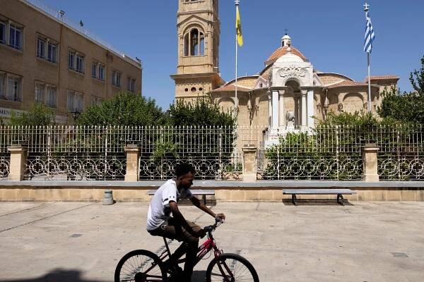 A man rides his bicycle outside the Panagia Faneromeni church in Nicosia
