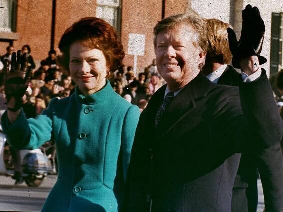 a man and woman wave to the crowd