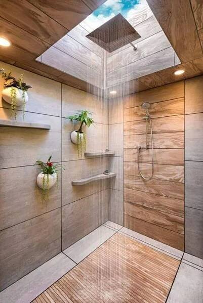a shower with wooden walls and flooring next to a skylight in a bathroom