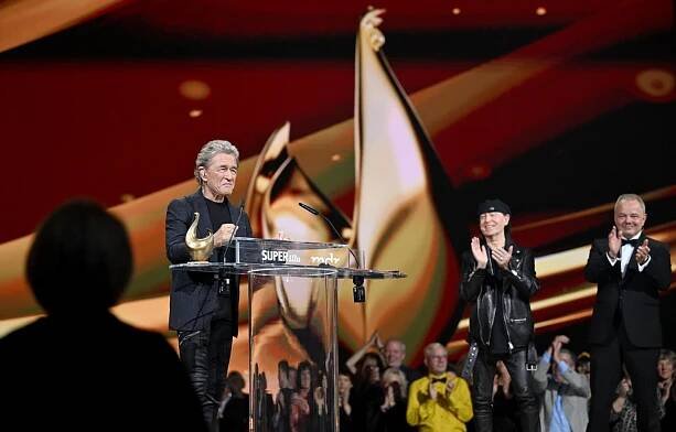 Peter Maffay (l) steht bei der Verleihung des Medienpreises Goldene Henne auf der Bühne. Er wird in der Kategorie Lebenswerk ausgezeichnet. Klaus Meine von den Scorpions (M) und Stefan Kobus, Chefredakteur der Super Illu, applaudieren. 