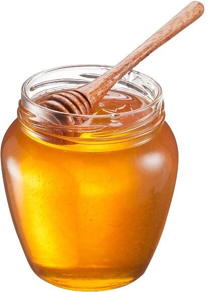 Glass jar of honey with wooden honey dipper.