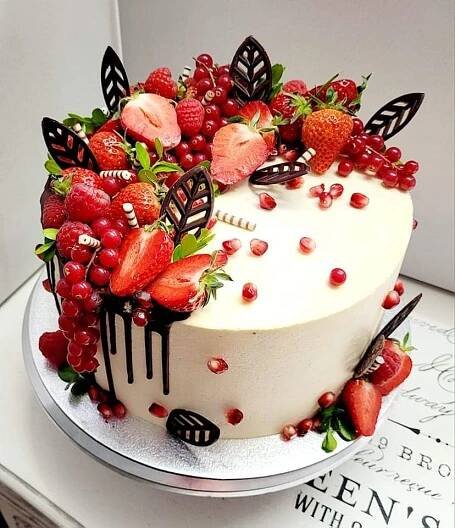 a white cake with berries and butterflies on top