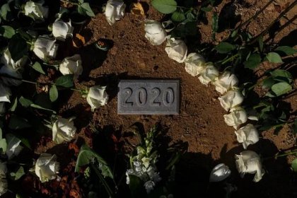 A communal grave for the unclaimed county residents who died in 2020 is adorned with roses during the Los Angeles County ceremony for them at a county cemetery in Los Angeles, Thursday, Dec. 14, 2023. This year's service laid to rest 1,937 people who died unclaimed in 2020. They were immigrants, children, people experiencing homelessness or poverty, and, for the first time, victims of the coronavirus. (AP Photo/Jae C. Hong)
