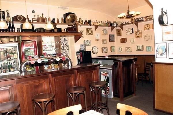a bar with wooden cabinets and bar stools at Penzion Aladdin in Teplice