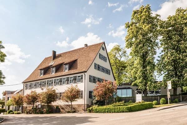 Rebers Pflug Hotel und Restaurant in Schwäbisch Hall-gepflegtes Landhaus mit Restaurantanbau bei strahlendem Sonnenschein und blauem Himmel