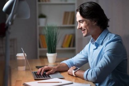 man-using-his-laptop-while-smiling-how-to-write-a-cover-letter
