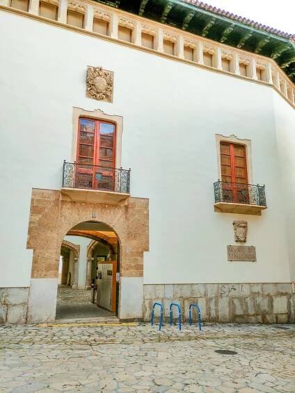 a building with an arch leading to a courtyard, the entrance of the museum of Mallorca in Palma