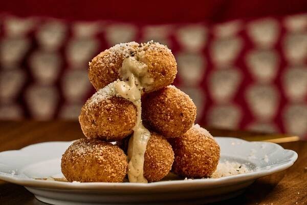 Stack of arancini with sauce oozing out of the top one at Bar Avoja