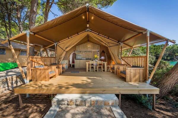 Luxuriöse Baldarin-Zeltunterkunft mit Holzterrasse in natürlicher Umgebung