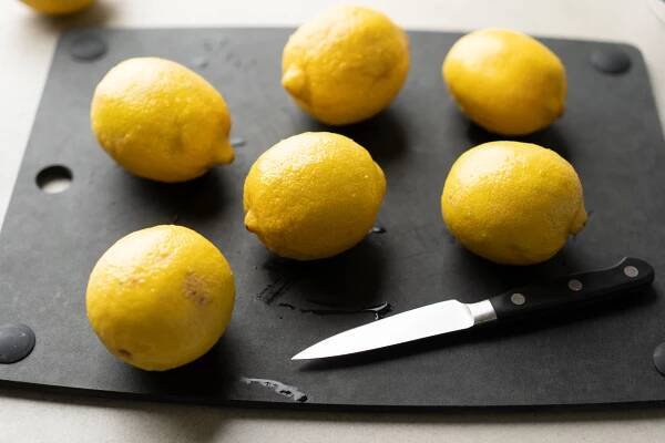 six lemons on black cutting board