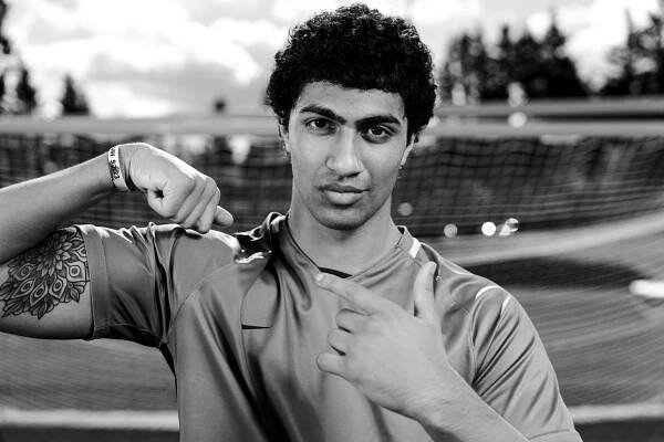 A senior from the Woodinville High School varsity men's soccer team, pointing to his biceps.