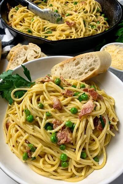 Overhead look at pasta carbonara in a bowl and in a skillet.
