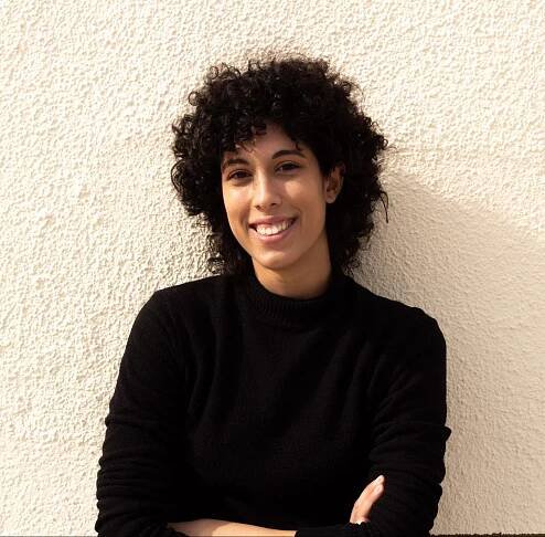 The photo shows a woman smiling to the camera.
