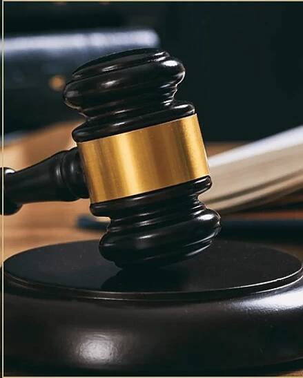 Photo of a dark wood gavel with gold trim on it