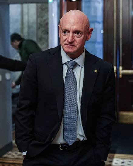 A photo of Mark Kelly wearing a dark suit at the Capitol. 