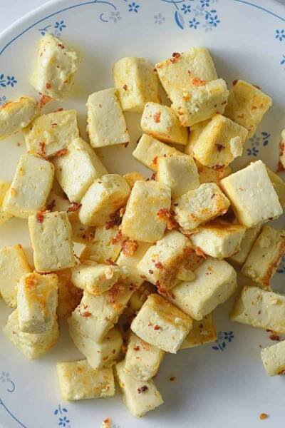 cooked paneer cubes on a plate.