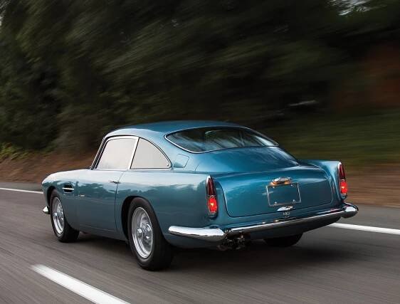 The elegant beauty of the Aston Martin DB4 as commonly admired from a rear quartering angle as one is passed by one.