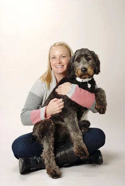 grey sheepdog with woman with grey backdrop
