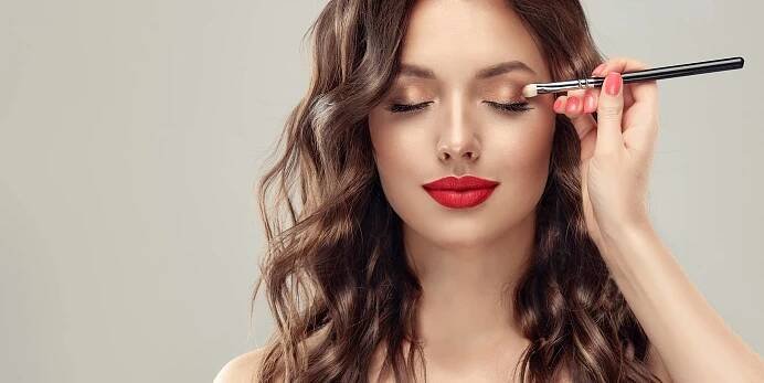 Make-up malíř aplikuje oční stíny. Krásná ženská tvář. Ruka visagistky, malování kosmetiky mladé modelky krásy. Doplnit v procesu — Stock obrázek