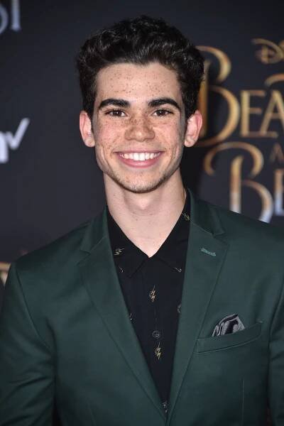 Cameron Boyce in a green suit.