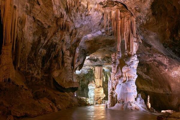 A cave with enormous stalagmites and stalactites, and a path for tourists.