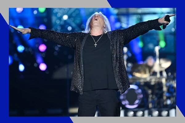 Def Leppard frontman Joe Elliott soaks in the moment with his arms outstretched and head thrown back while onstage.