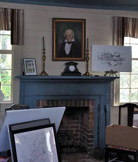 fireplace with Portrait of John Carson above mantel - antique mantel clock - historical drawings of the Carson House and maps