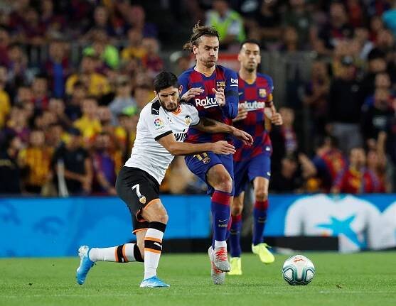Antoine Griezmann z Barcelony (uprostřed) a Gonçalo Guedes z Valencie bojují o...