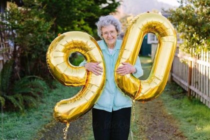 Elderly Woman Holding Number Balloons For Ninetieth Birthday