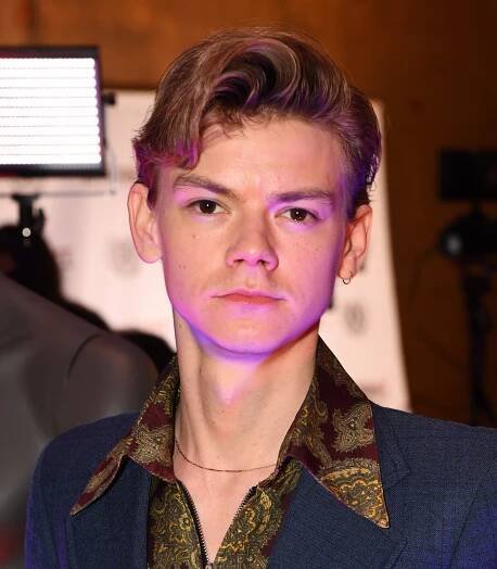Thomas Brodie-Sangster wears a navy suit and minimalist jewelry at the 28th Raindance Film Festival