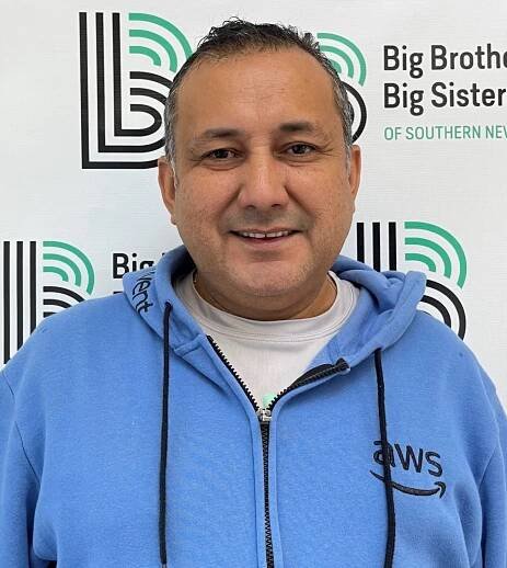 Omar Gomez, Donation Center Driver, smiling and wearing a blue hoodie