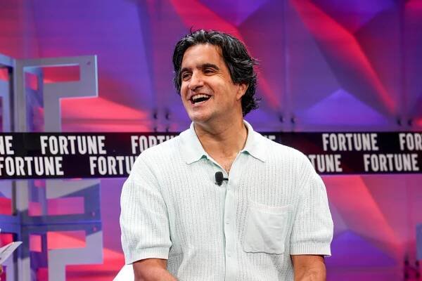 man wearing polo shirt sitting onstage