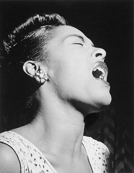 Billie Holiday singing, black and white photo.