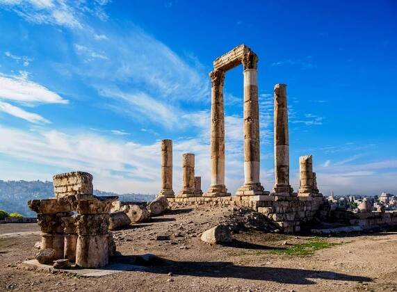 a row of stone columns with a blue sky in the background