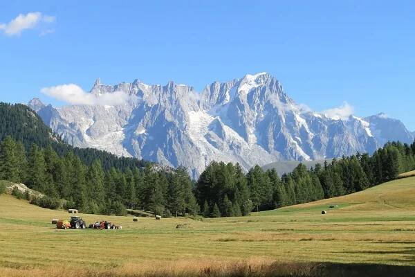 Mont Blanc v létě, nejvyšší hora Alp a Evropy, obklopená zelenými údolími a horskými stezkami.