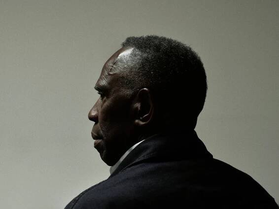A portrait of Charles Gaines from over his left shoulder in front of a gray background.