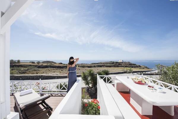 Dining table and sun lounger on the sea view veranda of the oia sunset luxury villa in oia santorini