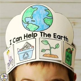 a young boy wearing a paper crown with pictures of the earth and plants on it