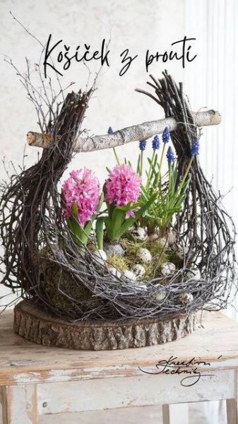 a wooden table topped with a bird nest filled with flowers