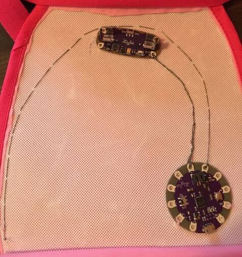 Pink purse with LilyPad Arduino and battery sewn into place