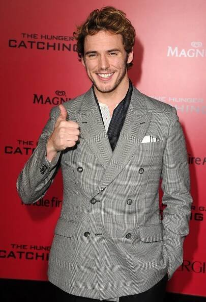 a man in a suit giving the thumbs up