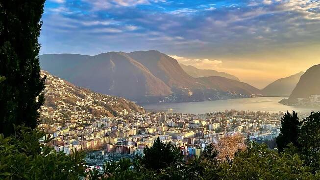 blick auf den lugano see und lugano im sonnen untergang