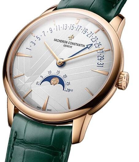 The Vacheron Constantin Patrimony Moon Phase Retrograde Date is a limited edition wristwatch in 18K pink gold, with a green leather strap, white dial, gold markers, retrograde date display, and a moon phase at 6 o’clock.