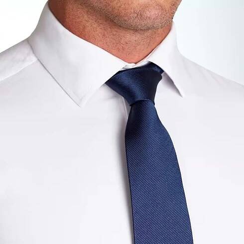 Man wearing a white dress shirt and a blue tie on a white background