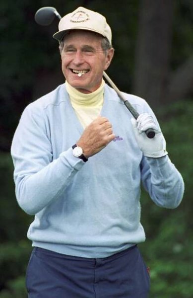 President George Bush, clenching a golf tee between his teeth, entertains reporters questions on his upcoming Supreme Court Justice nomination prior to a round of golf near the vacation home